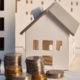 Münzen stapeln sich vor Spielzeughaus; Immobilienfinanzierung